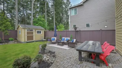Expansive paver patio has room for seating and dining. Don't forget the storage shed!