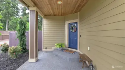 Cozy and inviting covered front porch with beautiful blue front door.