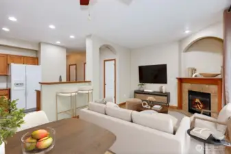 Digitally staged living room and view of kitchen.