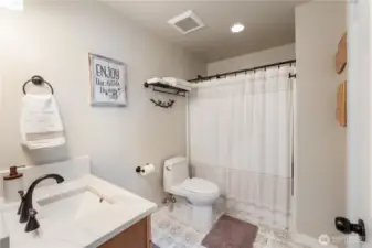 Quartz vanity and custom tile floor.