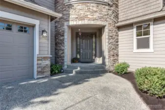 “Inviting covered front porch framed by a rounded stone turret—lending timeless elegance with a touch of castle-like charm. A storybook entry that sets the tone for the home’s craftsmanship and warmth.”