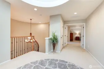 “Loft landing filled with natural light, where French doors open to the primary bedroom suite.”