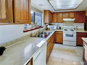View of the kitchen from the entry way...all appliances stay.  You will enjoy the bright and sunny south facing window above the sink.