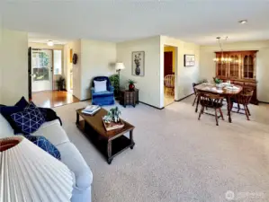 Formal rooms as looking toward the entry way with laminate floor and front door with side panel windows.