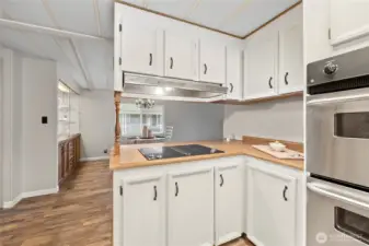 Glass cooktop with built in Downdraft Vent. Faces counter top seating area and Dining Room