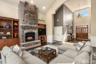 Great room offers souring 1.5 story floor to ceiling windows, custom stone to ceiling gas fireplace and custom built-ins