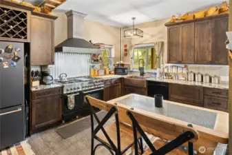 Gorgeous kitchen. Wine racks, cute lighting, solid surface counters & plenty of storage too. Lovely stamped concrete floors!