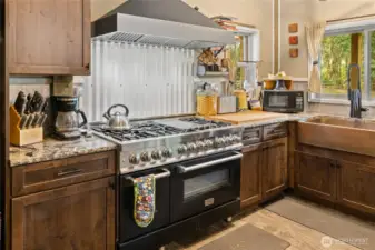 Commercial dual heat/double oven & gas range! A dream kitchen for sure. The farmhouse sink is copper & ties in the rustic flair.