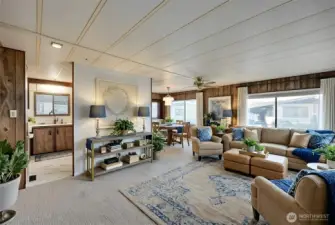 Living room flows to dining room and kitchen. Digitally staged, including curtains.