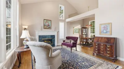 The living room has hardwood floors, a gas log fireplace with a white enamel fireplace surround.