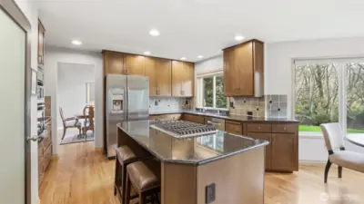 The kitchen has been nicely updated with newer appliances, granite counter tops, tile backsplash, center island with eat bar and the gorgeous views of your own private backyard.