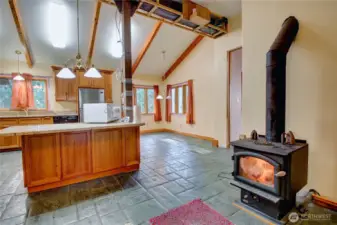 looking into the kitchen w/ cozy wood stove