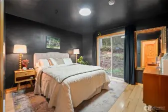 The primary bedroom has its own sliding glass door to the outside. Enjoy nature, listen to the creek/waterfall, or add your own patio area if you want!