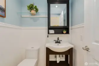 Charming half bathroom on the main level with wainscoting.