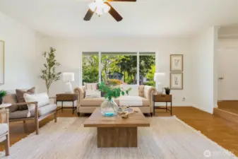 Bright living room with a large front window that floods the room with natural light.