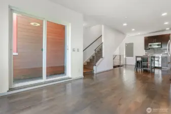 View from living room looking at slider to BBQ patio & stairs to 4th floor.