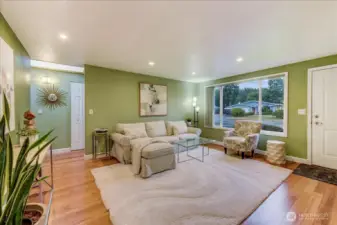 Comfortable living space, updated windows wood floors, and a electric fireplace on the wall to the right.