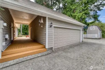 Double car garage with additional upper level workshop/storage ares. Separate custom  built shop located next to the garage. Note the back entrance to the home on the left of the breezeway.