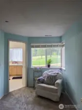 Peaceful reading corning in the primary ensuite with door leading to the 3/4 bathroom.  Notice the view of the golf course from these windows.