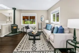 Open living space; great light- newer finishes, plus access to a covered deck. Notice the cozy wood stove / fireplace and A/C.