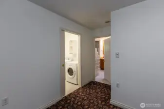 View from primary bedroom showing entry to laundry room and to primary bath.