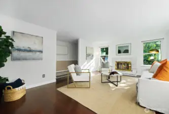 Enter to a formal living room with wood burning fireplace, dark wood floors and big windows with verdant views.