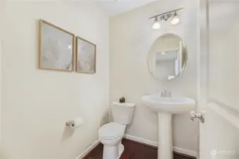 Main floor powder room with pedestal sink and privacy fan that guests will appreciate!