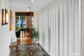 A study in mid-century restraint, the main-level Gallery Hall draws on Tucker & Shields’ mastery of rhythm and proportion. With slate flooring underfoot, crisp vertical panels to the right, and framed views ahead, this transitional space balances architecture and art, movement and pause.