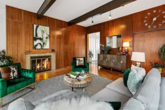 A closer look at the Living Room reveals the rich materiality and detailing of the 1963 Tucker & Shields design. Vertical grain fir paneling, mid-century built-ins, and a commanding brick hearth lend both warmth and gravitas—while the space remains fluid, connected to gallery hallways and expansive garden-facing glass.