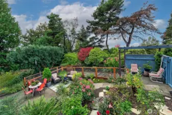 A hidden garden terrace on the west side of the home reveals a world of abundance—raised beds, fruit trees, flowering borders, and sun-drenched patios alive with possibility. With views toward Puget Sound and privacy from mature hedges, this vibrant outdoor level functions as both sanctuary and stage for entertaining, cultivating, and reconnecting with the land.