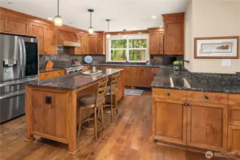 Custom remodeled kitchen with an abundance of cabinets thoughtfully designed for efficient storage! Slab granite counter top. Large Center island for casual bar dining.