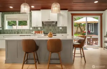 Featuring sleek quartz countertops and stunning cabinetry, this kitchen provides generous prep and storage space.