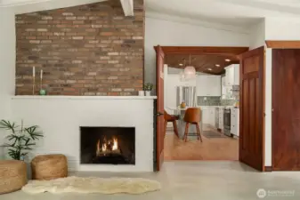 The wood-burning fireplace is a warm focal point, flanked by double doors that offer flexible living from the great room into the Kitchen.