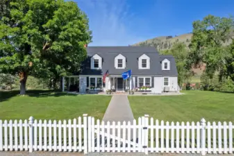 The heart of Marble Ranch—a lovingly preserved 1930s farmhouse with classic dormers, covered porch, updated systems, and timeless curb appeal framed by mature trees and manicured lawn.
