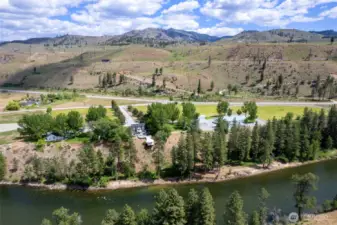 Overhead View: From above, Marble Ranch showcases expansive grounds, a long tree-lined drive, and a charming home nestled among rolling hills.