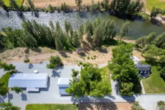 Aerial perspective of Marble Ranch shows the spacious layout: 1930s farmhouse, guest house, and 7,000 SF shop—set just above a half-mile of private Methow River shoreline and forested trails.