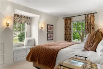 Sunny and spacious upstairs bedroom (primary); classic charm with built-in window seat, cozy textures, full of comfort and bright windows.