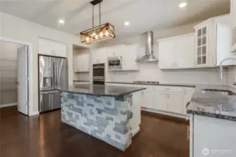Kitchen island has a stone front that matches the fireplace
