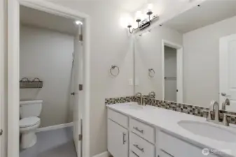 Upstairs bathroom has dual sinks, quartz counters, tile floors and separate shower, tub and toilet area