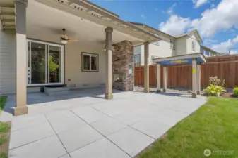Fully covered patio with remote ceiling fans and gas fireplace.