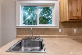 Clean counters and tile backsplash grace this space.
