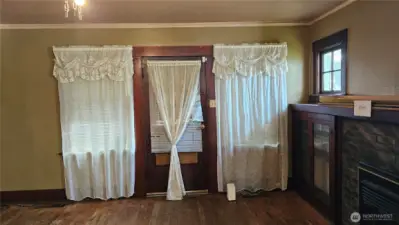 big windows in LR looking out front door to covered porch