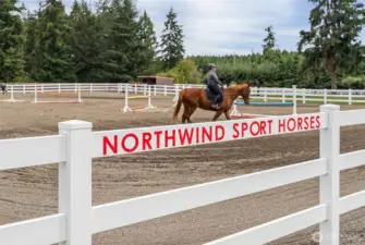 Up-close look at the outdoor arena, beautifully enclosed with vinyl fencing for a clean, polished appearance. The arena features high-quality sand footing, providing optimal traction and comfort for horses during training or exercise.