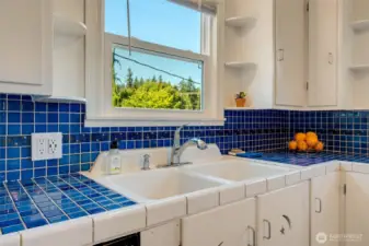 Tile backsplash with large, double sink.