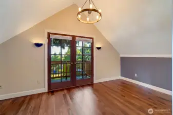 Primary bedroom with water view balcony outside the french doors.