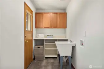 Main floor laundry with sink, folding table & storage