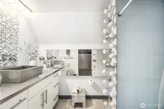 ¾ Bath  Walk-In Closet with built-ins, lots of hanging space and cabinets with shelves  Bathroom:     Walk-in shower with glass tile and custom niches     Single vanity with glass tile backsplash detail, stainless-steel sink, and custom stainless-steel counter      Large horizontal mirror