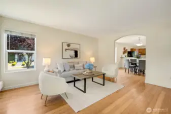 Living room with double arched entry to the kitchen and dining area.