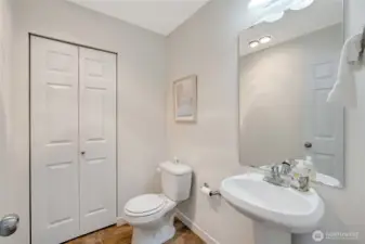 Half bathroom on main with closet. Closet holds the hot water heater and additional shelving for storage.
