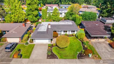 Overhead photo of front of the home. Flat driveway into 2 car garage.
